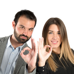 Couple making Ok sign over white background