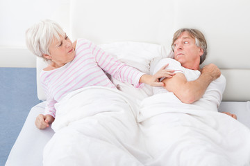 Angry Couple Lying On Bed