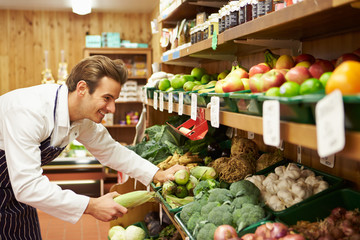 Male Sales Assistant At Vegetable Counter Of Farm Shop