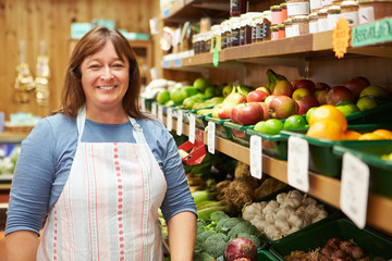 Female Sales Assistant At Vegetable Counter Of Farm Shop