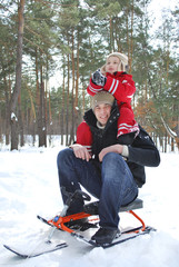 Winter in the woods dad holding his son on his shoulders.