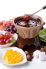 Chocolate fondue with marshmallow candies and fruits, isolated