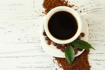 Cup of coffee with instant coffee on wooden background