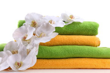 Obraz na płótnie Canvas Kolorowe ręczniki i kwiaty orchidei, odizolowane na białym