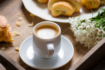 Breakfast in bed with espresso, flower and croissant