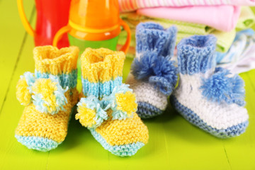 Fototapeta na wymiar Composition with crocheted booties for baby,clothes, bottles