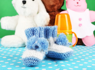 Composition with crocheted booties for baby, bottle, toy and