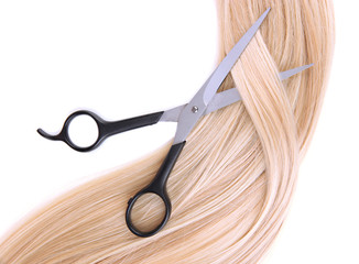 Long blond hair and scissors isolated on white