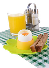 Boiled egg in egg cup on table close-up