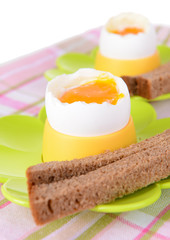 Boiled eggs in egg cups on table close-up