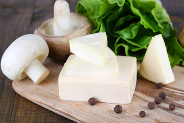 Cream cheese with vegetables and greens on wooden board