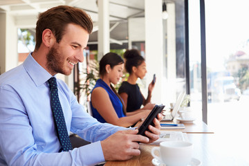 Businessman Using Digital Tablet In Coffee Shop