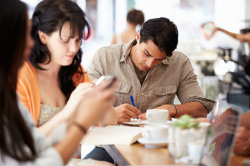 Customers In Busy Coffee Shop