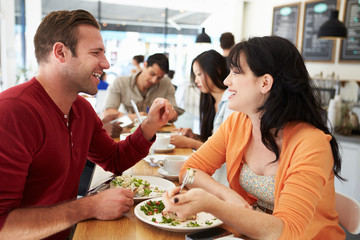 Couple Meeting For Lunch In Busy Café