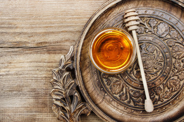 Bowl of honey on wooden table. Symbol of healthy living