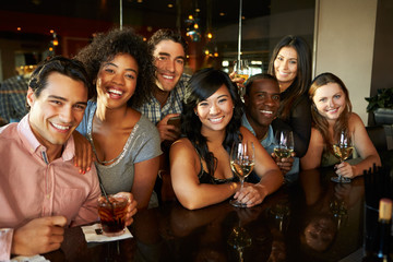 Group Of Friends Enjoying Drink At Bar Together