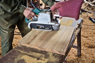 Hands of a carpenter planed wood