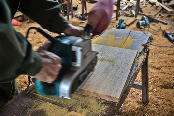 Hands of a carpenter planed wood