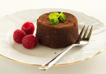 Chocolate fondant (pudding) with raspberries.