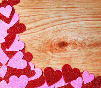 Valentines Day background. Glitter Red and Pink Hearts on Wooden