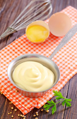 mayonnaise in metal spoon on wooden board