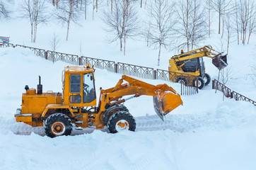 Snowplows on clearing snow drifts.