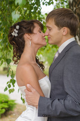 Young wedding couple kissing. Romantic portrait.