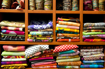 Colorful scarfs on a shelves background