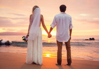 Married couple, bride and groom at sunset on beautiful tropical