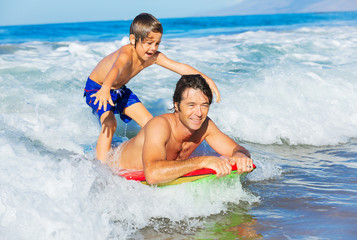 Obraz premium Father and Son Surfing Tandem Togehter Catching Ocean Wave, Care
