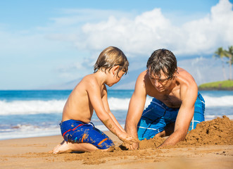 Fototapeta premium Father and son playing together in the sand on tropical beach