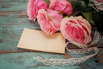 Pink roses on a wooden table. Vintage