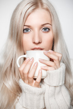 Blonde woman drinking a cap of tea