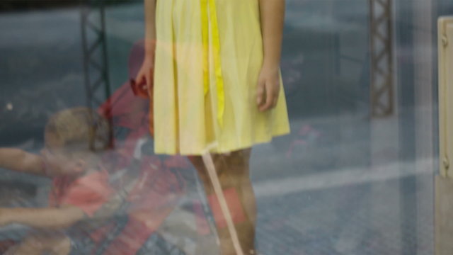 Young girl passing by a shoe shop