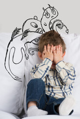 Scared boy hiding his face. Sketches of his fictional fears arou