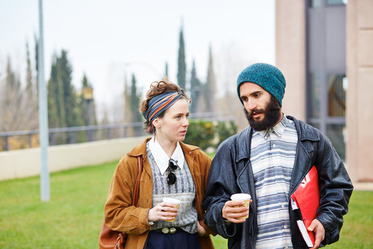 Hipster Couple Talking And Drinking Coffee To Go