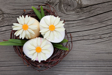 Obraz na płótnie Canvas Easter eggs and flowers in a nest