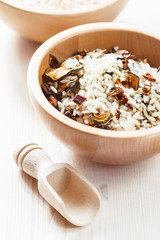Rice in wooden bowl with ingredients for risotto
