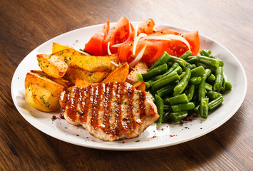 Grilled steak, baked potatoes and vegetables