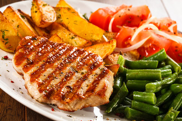 Grilled steak, baked potatoes and vegetables