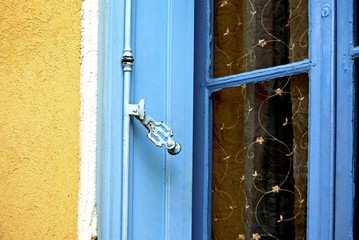 Yellow stone building with blue window frame.
