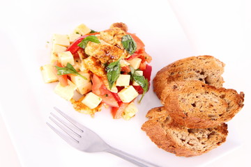 Chicken, cheese & vegetable salad with some bread on a plat