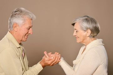 elderly couple holding hands