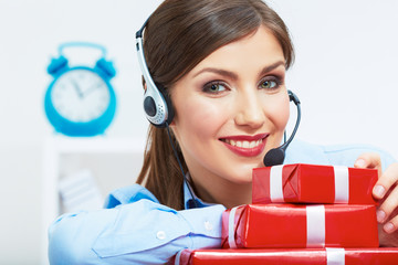 Smiling operator seat at table with red gift box. Happy busines