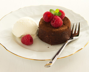 Chocolate fondant (pudding) with raspberries.