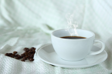 Coffee cup and beans on silk tablecloth