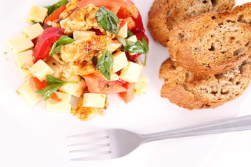 Chicken, cheese & vegetable salad with some bread on a plat