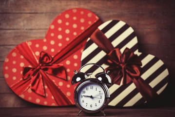 Retro clock and gift in heart shape on the background.