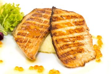 Grilled salmon fillet with vegetables and caviar