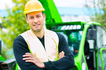 Bauarbeiter vor Baumaschine einer Baustelle